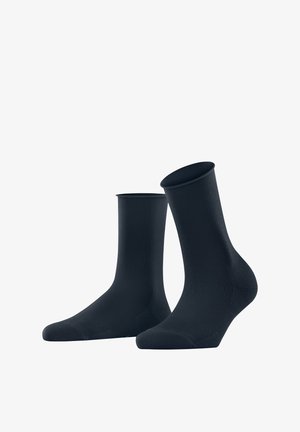 Calze nere alla caviglia realizzate in un tessuto liscio e elastico, con un motivo a coste nella parte superiore e rinforzi nella punta e nel tallone.