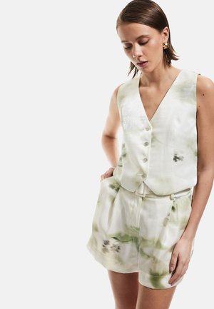Witte mouwloze pak met een diepe V-hals, voorzien van een subtiel groen aquarelpatroon, vijf knopen en een bijpassende tailleband op de shorts.