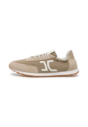 Lichtbruine en beige lage sneaker met wit logo, veters en gumzool, zijaanzicht op een witte achtergrond.