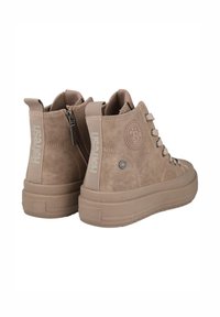 Zapatillas altas marrones de textura de ante, con un parche de logo, cordones en la parte delantera, cremallera plateada y una suela de goma gruesa.