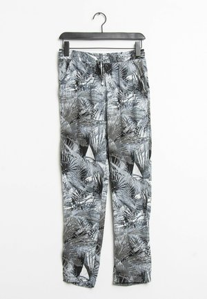 Zwart-witte geprinte broeken met een palmbladpatroon, elastische tailleband en trekkoordsluiting, hangend aan een zwarte hanger.