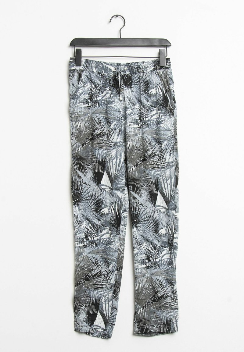 Zwart-witte geprinte broeken met een palmbladpatroon, elastische tailleband en trekkoordsluiting, hangend aan een zwarte hanger.
