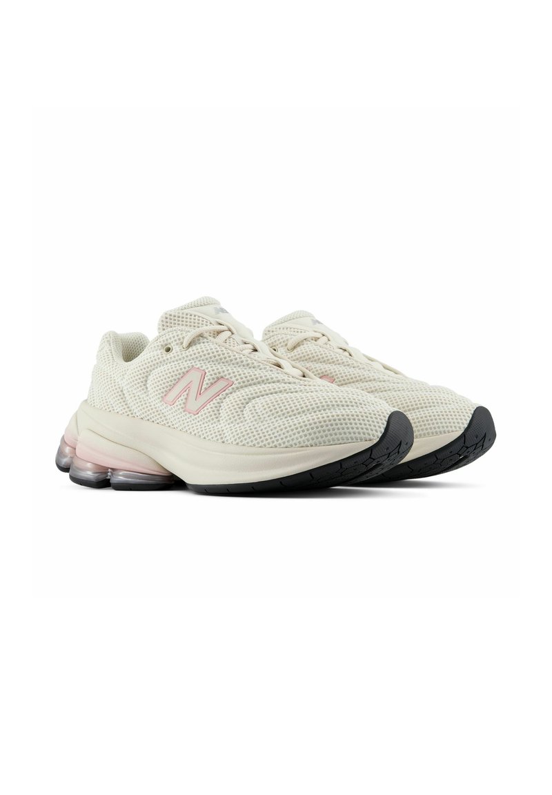 Coppia di scarpe da ginnastica sportive in mesh bianco sporco con logo N rosa, suola spessa e suola esterna nera testurizzata, viste da un leggero angolo.