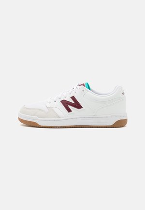 Białe niskie sneakersy New Balance z bordowym logo "N", beżowym zamszowym noskiem, turkusowym detalem na języku oraz gumową podeszwą, widziane z boku.