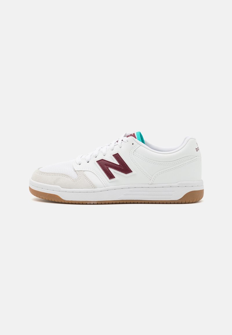 Baskets basses blanches New Balance avec logo "N" bordeaux, bout en daim beige, détail de la languette bleu sarcelle et semelle en gomme, vues de côté.