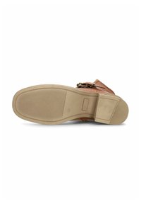 Sandale en cuir marron avec une sangle texturée, une boucle ajustable et une semelle en caoutchouc présentant des rainures horizontales pour une meilleure adhérence.
