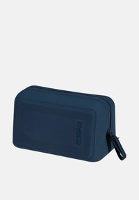 Borsa in silicone blu navy dalla forma rettangolare, superficie texturizzata, chiusura con cerniera e dettaglio del logo impressa. Ideale per organizzare accessori.
