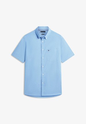 Camisa azul claro de manga corta con botones en la parte delantera, un bolsillo frontal y un pequeño logo bordado en el bolsillo, colocada sobre un fondo blanco.