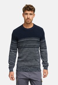 Merensin navy blue -värinen neulepaita, jossa on vaakasuuntaiset tummanharmaat ja vaaleanharmaat raidat, pyöreä kaula-aukko ja pitkät hihat. Pehmeä rakenne.