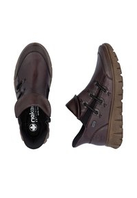 Chaussures en cuir marron avec un design de cheville basse, des lacets élastiques et une semelle en caoutchouc texturée. Présentent un talon plat et des accents de couture décoratifs.