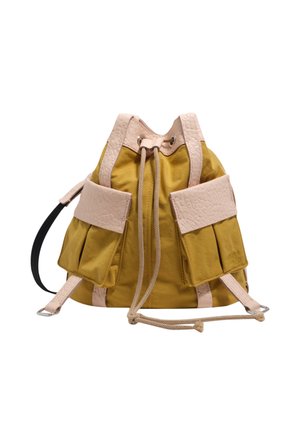 Żółty plecak w kształcie wiadra z beżowymi teksturowanymi paskami, przednimi kieszeniami i zamknięciem na troczek na białym tle.