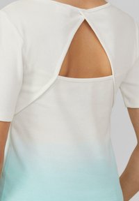 Weißes, geripptes Oberteil mit kurzen Ärmeln und einem Schlüsselloch-Rücken. Der untere Teil hat einen hellblauen Ombre-Verlauf, der ein strukturiertes Aussehen erzeugt.