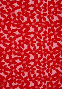 Raudona gėlių audinys su pasikartojančiu šešių žiedlapių gėlių raštu ant šviesiai rožinės spalvos fono su vertikaliomis įdubomis.