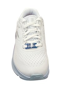Zapatilla deportiva blanca con parte superior de malla transpirable, diseño de cordones y una etiqueta azul "LAVABLE A MÁQUINA". Suela de goma texturizada.