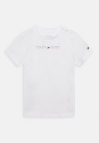 Camiseta de algodón blanca con mangas cortas, que presenta un logo multicolor de "TOMMY HILFIGER" en el frente y un pequeño logo en la manga.
