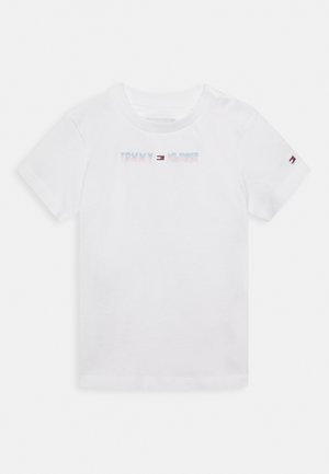 Camiseta de algodón blanca con mangas cortas, que presenta un logo multicolor de "TOMMY HILFIGER" en el frente y un pequeño logo en la manga.