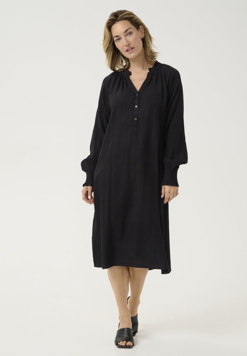 Must musta sleeve dress, millel on nööpidega nööppluus, kogutud kaelus ja tekstureeritud kangas. Omaduseks on puhvis varrukad ja see ulatub põlvest allapoole.