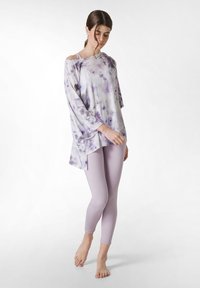Fialový top s tie-dye vzorem, volného střihu a asymetrickým lemem, doplněný o jednobarevné levandulové legíny. Měkký, lehký materiál.