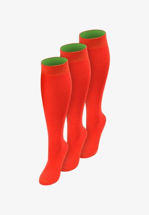 Drei Paar leuchtend rote knielange Kompressionsstrümpfe mit grüner Innenfütterung, aufrecht vor weißem Hintergrund präsentiert.