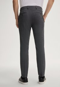 Grau karierte Hose aus einem strukturierten Stoff, mit schmaler Passform, standardmäßigen Gürtelschlaufen und zwei Gesäßtaschen mit Knopfverschluss.