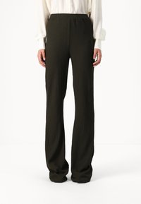 Dark green, textured wide-leg trousers with a high waist, featuring a smooth, elastic waistband and no visible hardware.