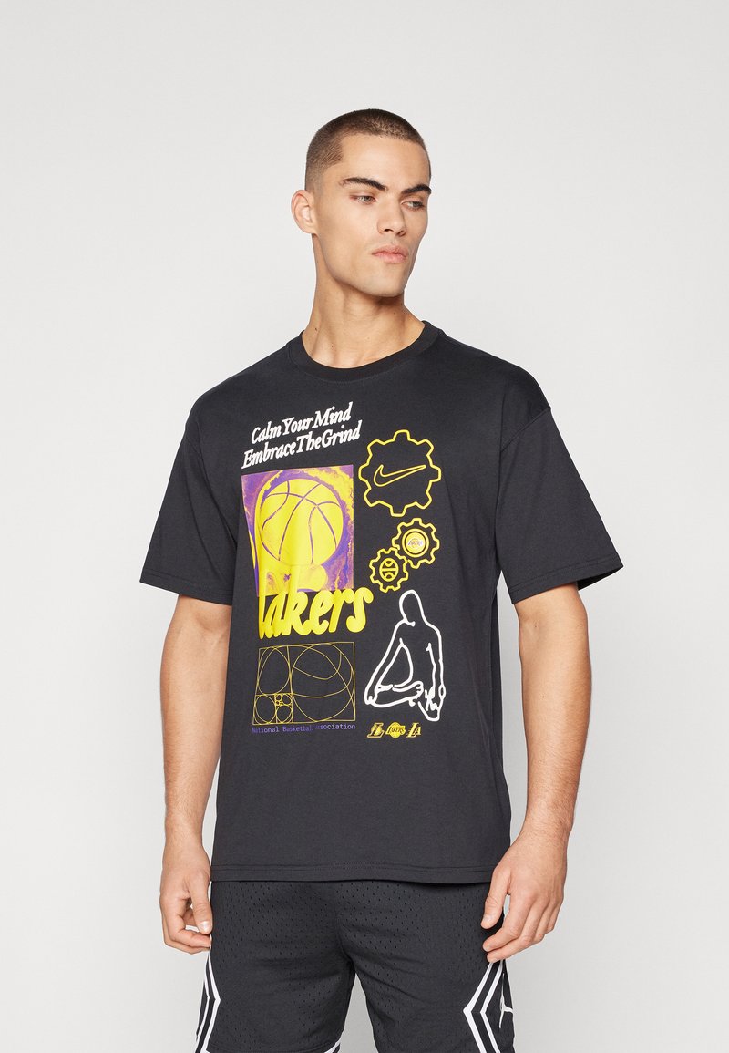 Černé bavlněné tričko s barevnými grafikami včetně basketbalového míče, textu "Lakers" a loga Nike. Krátké rukávy, volný střih.