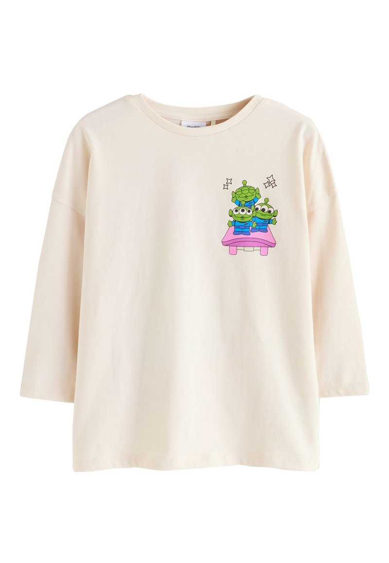 Cream-colored short-sleeve t-shirt made of cotton, featuring a graphic of three cartoon aliens on a pink table, with sparkling accents.
