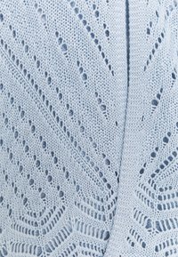 Jasnoniebieski dziany kardigan z luźnym, teksturowanym wzorem, ozdobiony dekoracyjnymi oczkami i ukośnymi liniami na całej tkaninie.