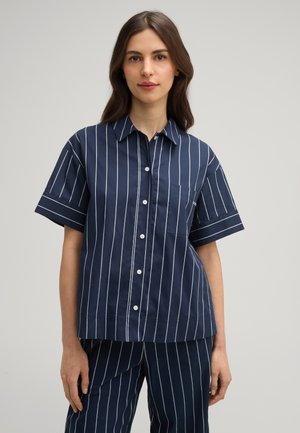 Marineblaues kurzärmliges Hemd mit weißem vertikalem Streifenmuster und einer Brusttasche. Mit einem Kragen und umgeschlagenen Ärmeln. Glattes Baumwollmaterial.