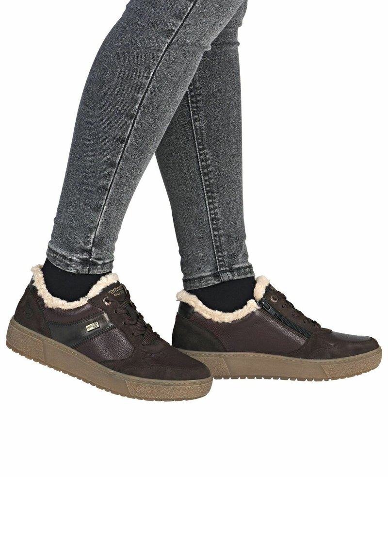 Braune Sneakers mit einem strukturierten Leder-Obermaterial, Kunstfell-Futter am Kragen und einer Gummisohle. Mit seitlichem Reißverschluss für einfaches Anziehen.