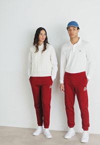 Lacoste SUBTLE LOGO TRACKPANT UNISEX  - Treningo apatinė dalis - ora