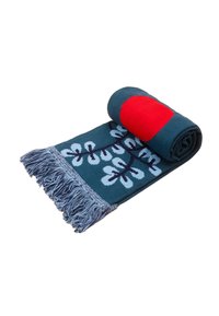 Woven scarf o intensywnym niebiesko-zielonym tle, z białym kwiatowym wzorem i jednolitym czerwonym akcentem. Wykończony frędzlami z jednej strony. Miękka faktura.