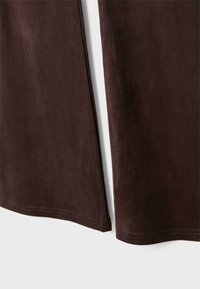 Braunes Wildledergewebe mit einer glatten Textur, das einen sauberen Rand und subtile Stichdetails am Saum aufweist und ein minimalistisches Design präsentiert.