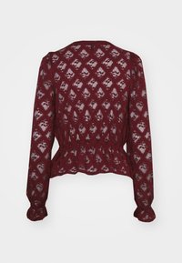 Burgundi pitsiga blouse pikkade varrukatega, peplum vöökoht, keeruline teemantimuster ja karbikujulised mansetid. Tagakülg näitab läbipaistvat kangast.