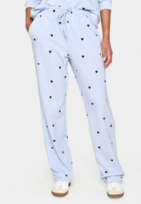Pantaloni felpati azzurri con vita elastica e cordino, caratterizzati da un motivo di piccoli cuori neri in tutto il tessuto.