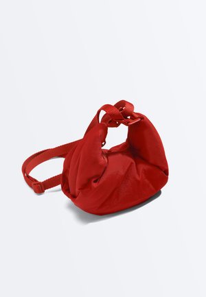 Zachte rode stoffen crossbodytas met verstelbare riem en geplooid ontwerp, afgebeeld tegen een effen witte achtergrond.