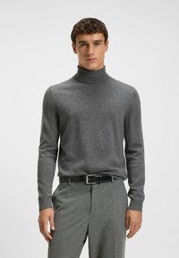 Szary sweter z golfem wykonany z miękkiego materiału, z długimi rękawami i ściągaczami, w zestawie z szarymi spodniami i czarnym paskiem.