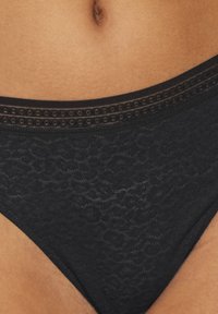 Schwarze Bikini-Briefs mit Muster und glatter Textur, ausgestattet mit einem dekorativen Gummibund und einem niedrigen Schnitt.