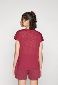 Burgundy short-sleeve t-shirt with a textured fabric, featuring a round neckline and a relaxed fit, paired with coordinating shorts.