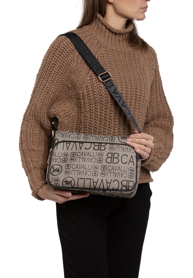 Borsa a tracolla beige con stampa nera del logo, forma rettangolare, chiusura con zip e tracolla regolabile. Tessuto testurizzato con dettagli del brand.