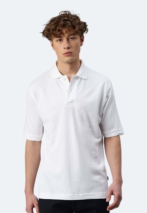 Polo bianco a maniche corte, con colletto e tre bottoni. Realizzato in tessuto texturizzato, presenta un piccolo etichetta laterale.
