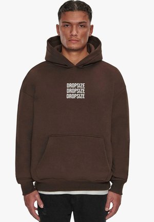 Brauner Kapuzenpullover aus weichem Stoff mit einer vorderen Tasche und Bündchenärmeln. "DROPSIZE" mehrfach in Weiß auf der Vorderseite aufgedruckt.