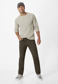 Gray ribbed long-sleeve shirt, olive green pants, and gray sneakers with white soles. Casual outfit, featuring a relaxed fit and soft textures.