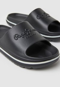 Sandales slides noires avec une bande blanche sur la semelle et un logo « Pepe Jeans London » en relief sur la sangle.