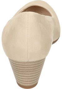 Beige suède pump met een ronde neus en een gladde textuur. Heeft een gestapelde, geribbelde hak en een laag uitgesneden ontwerp aan de achterkant.