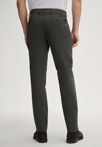 Dunkelgrüne Herrenhose mit geradem Schnitt, glatter Textur, zwei Gesäßtaschen und einem Bund mit Schlaufen für einen Gürtel.