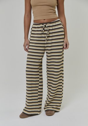 Szerokie spodnie w paski w kolorach żółtym, brązowym i białym, wykonane z miękkiego materiału, z regulowanym sznurkiem w pasie.