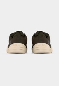 Σκούρα λαδί αθλητικά παπούτσια με μπεζ σόλες, που φαίνονται από πίσω, με υφή υφάσματος και θηλιές στα τακούνια.