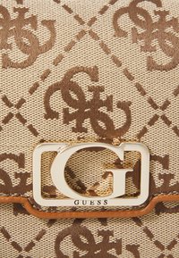 Borsa tote beige con superficie testurizzata e motivo a logo marrone, accentuata da un logo G in tono oro e rifiniture in pelle marrone.