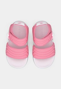 Roze sandalen met geribbelde textuur, verstelbare band en witte zool. Glad materiaal met een minimalistisch ontwerp. Logo gedrukt op de bovenkant.